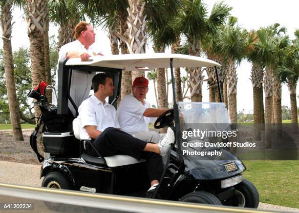 View of American football player Tom Brady and real estate developer Donald Trump in a golf cart at Trump International Golf Club, Palm Beach,...