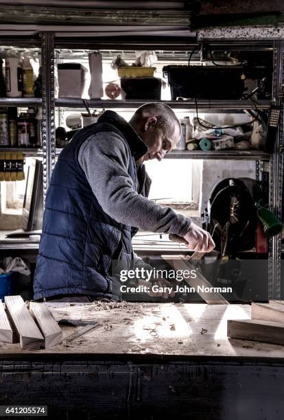 carpenter working at his bench in workshop, portrait. - sawdust stock pictures, royalty-free photos & images