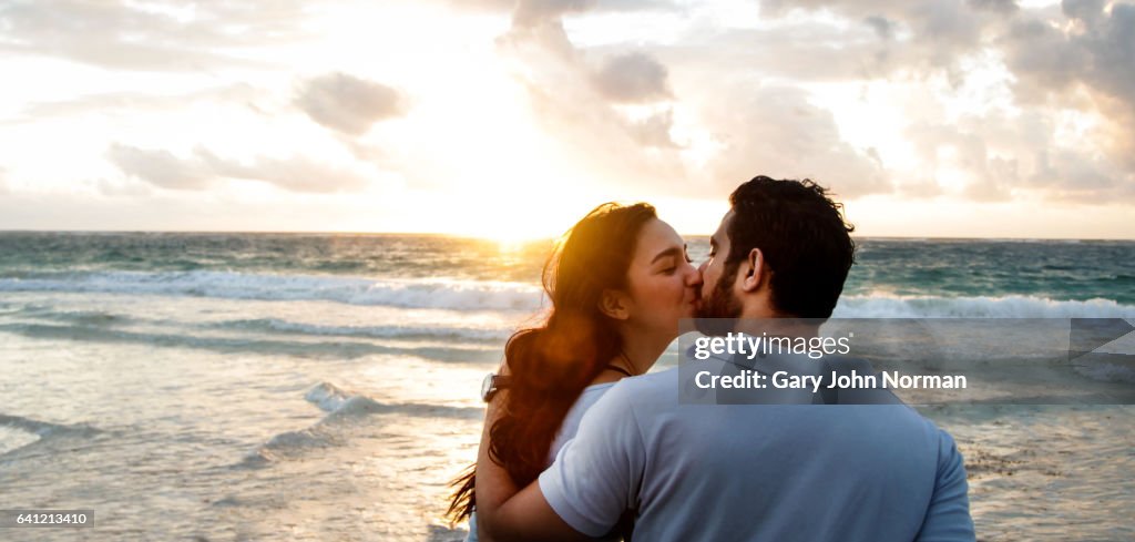 Happy couple kissing on beach.