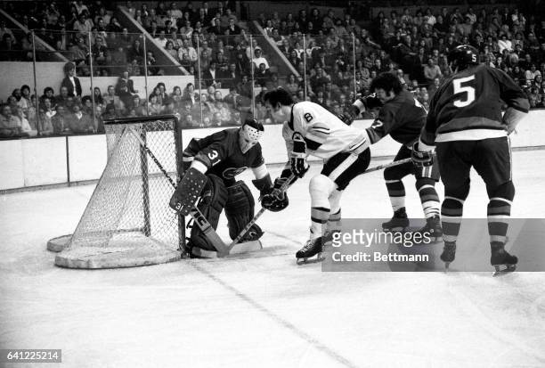 Bruins' Ken Hodge tries to jam the puck past New York Islanders' goalie Billy Smith, but to no avail as Smith protects his corner in 2nd period...