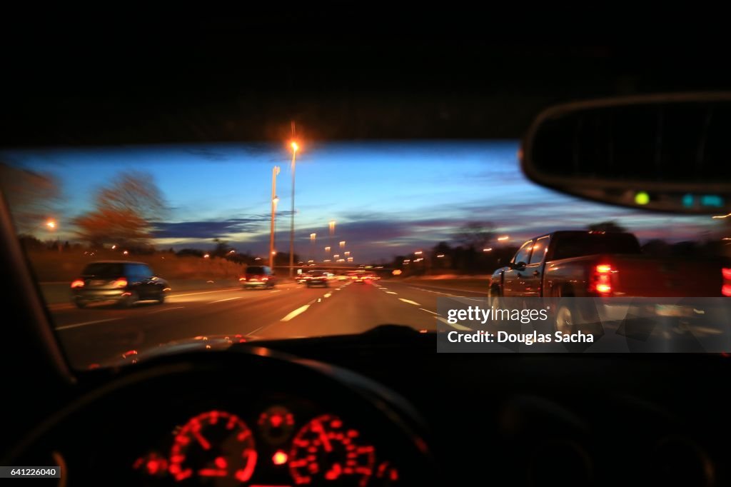 Dashboard view of a car moving on a highway in the evening hour