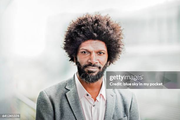 a portrait of a man with afro hair outside. - man with gray hair stock pictures, royalty-free photos & images