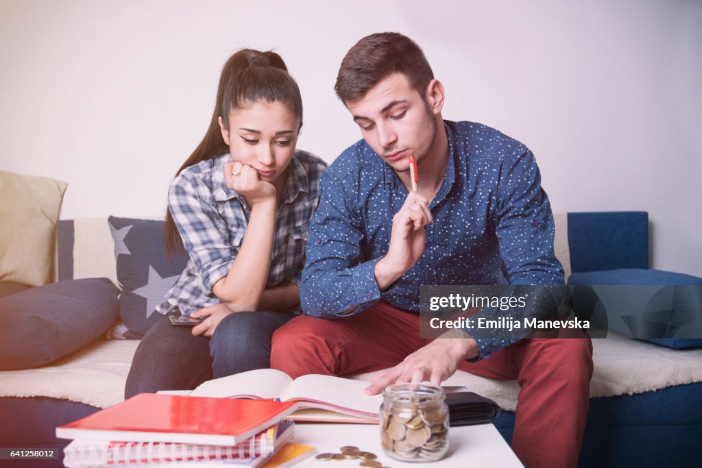 Portrait of worried young couple reading financial documents