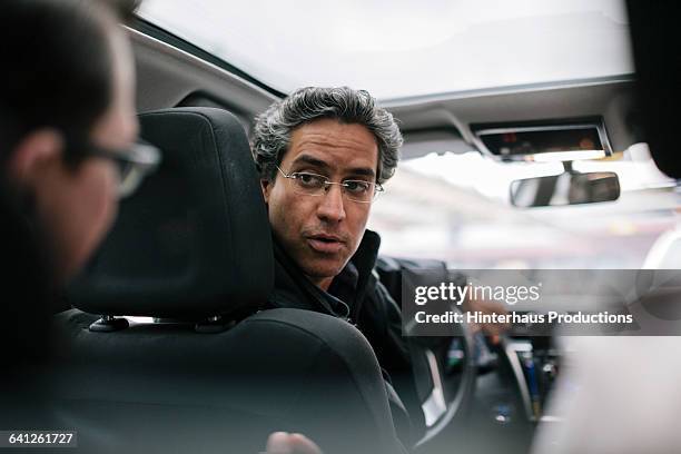 taxi driver talking to businessman - taxi van stockfoto's en -beelden