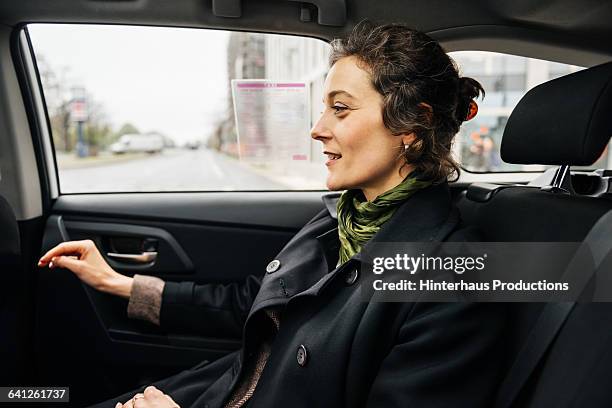 mature businesswoman travelling in taxi - car back seat stock pictures, royalty-free photos & images