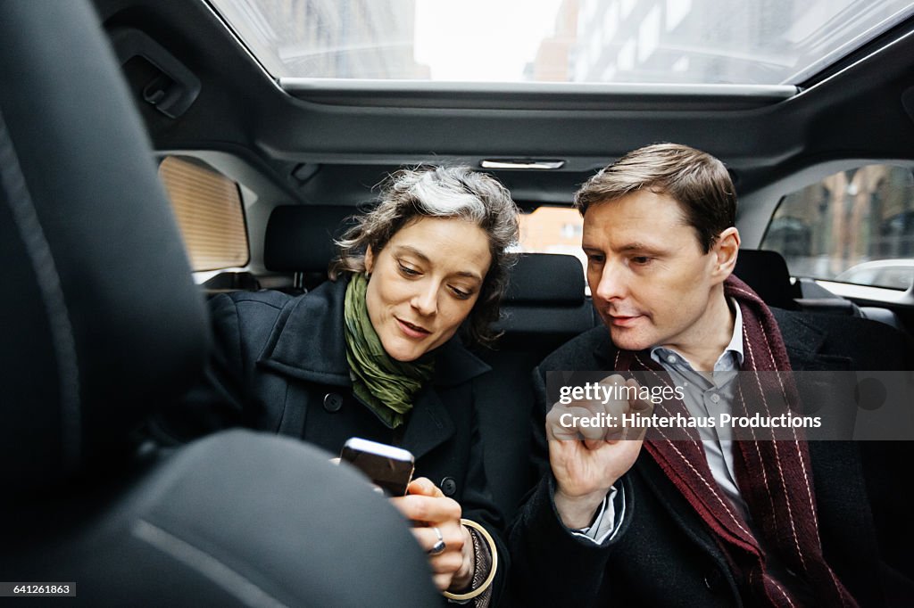 Business People with smart phone inside taxi