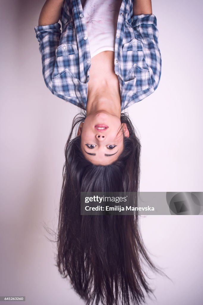 Pretty young woman hanging upside down