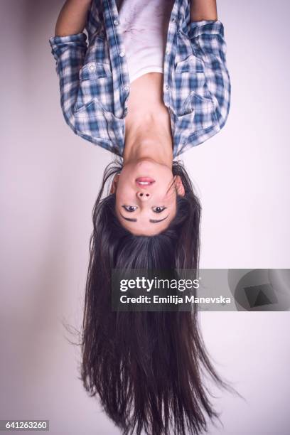 pretty young woman hanging upside down - capovolto foto e immagini stock