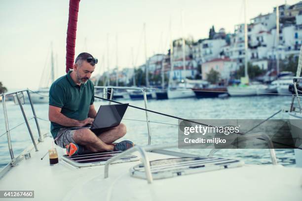 man sitting on sailboat's bow and enjoying - sailing greece stock pictures, royalty-free photos & images