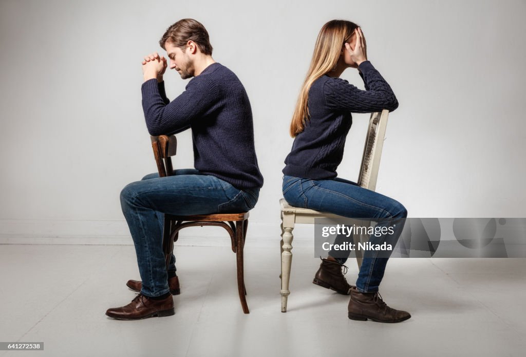 Seitenansicht des depressiv paar sitzen Rücken an Rücken auf Stühlen