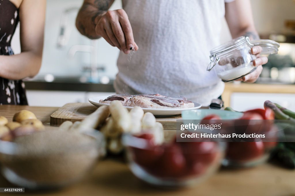Man seasoning meat