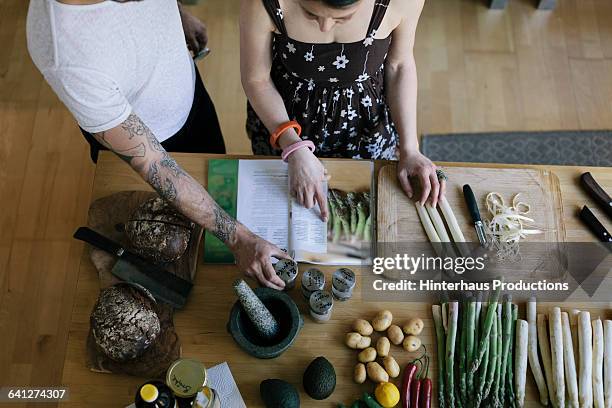 couple reading food recipe - cookbook fotografías e imágenes de stock