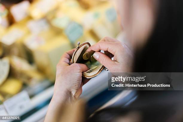 close-up of woman paying at market stall - münzbeutel stock-fotos und bilder