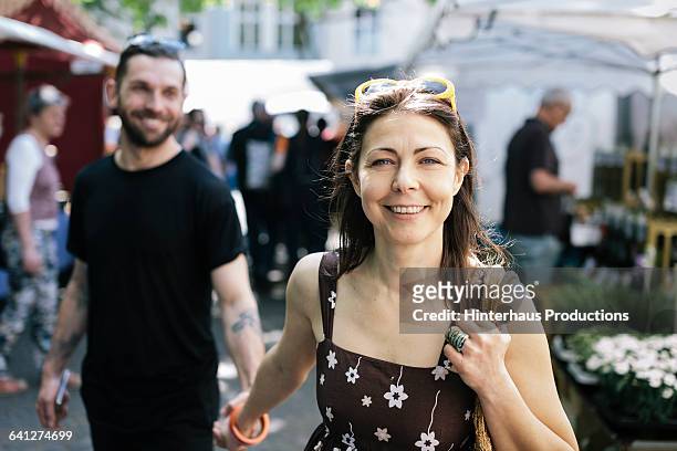 woman with boyfriend shopping at farmer market - personas en el fondo fotografías e imágenes de stock