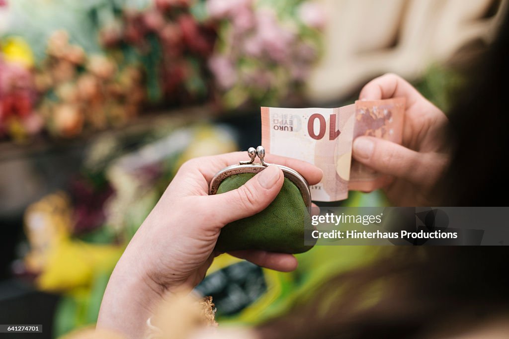 Woman paying for Flowers with 10 Euro Bill