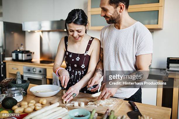 mature couple preparing food for dinner - woman couple at home stockfoto's en -beelden