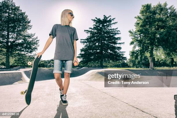 young woman standing with skateboard at skatepark - gray shorts stock pictures, royalty-free photos & images