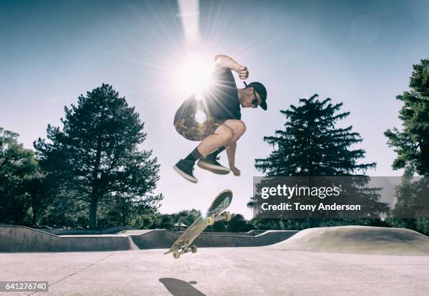 young man doing an ollie at skatepark - ollie pictures foto e immagini stock