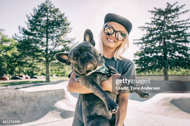 young woman with her dog at skatepark - french bulldog 個照片及圖片檔