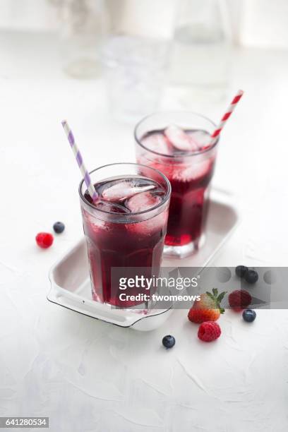 berry juice in drinking glass on white background. - rustic cocktails stock-fotos und bilder