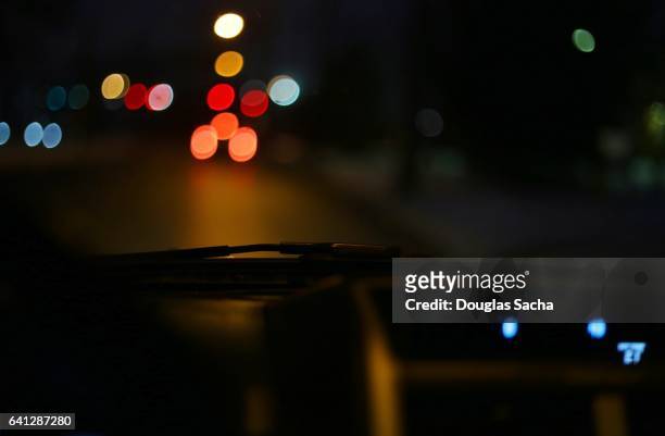 night time street life from a moving vehicle - dashboard camera point of view stock pictures, royalty-free photos & images
