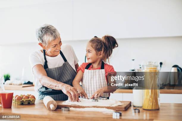 making cookies with grandma - grandmother granddaughter stock pictures, royalty-free photos & images