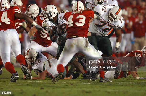 Clinton Portis of Miami carries the football against the defense of Scott Shanle during the Rose Bowl National Championship game at the Rose Bowl in...