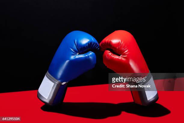 dueling boxing gloves - boxing glove stockfoto's en -beelden