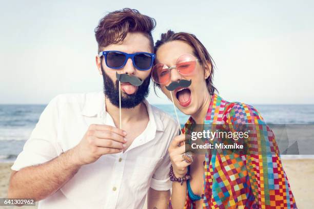 fake mustache fun - couple at beach sunny stock pictures, royalty-free photos & images