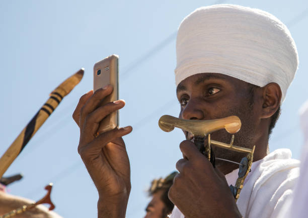 Priest of the ethiopian orthodox church taking pictures with his mobile phone on January 19, 2017 in Lalibela, Ethiopia.