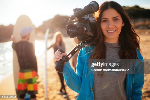 young smiling woman holding video camera - cinematographer imagens e fotografias de stock