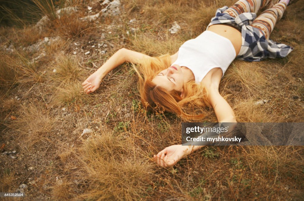 Woman lying on a grass in the mountains