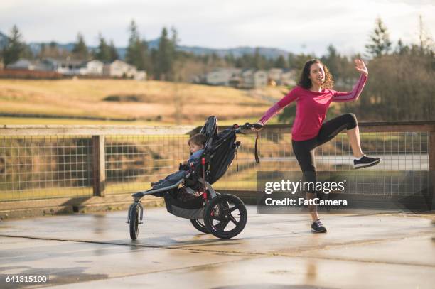 young mom jumping next to child in baby stroller - three wheeled pushchair stock pictures, royalty-free photos & images