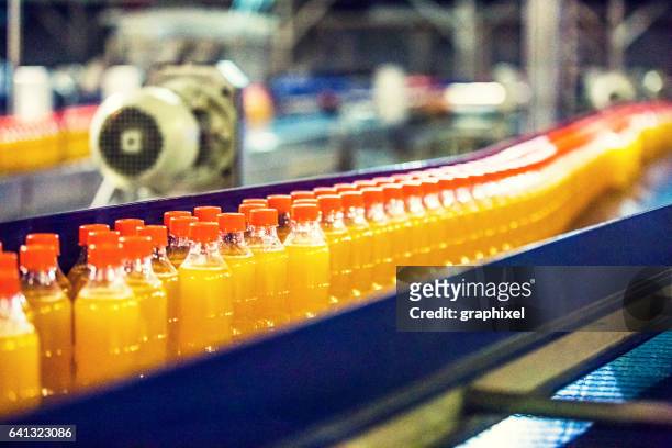 bottles on conveyor belt in factory - food and drink industry stock pictures, royalty-free photos & images