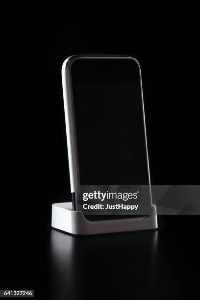 a phone standing on black background - kiosk stock pictures, royalty-free photos & images