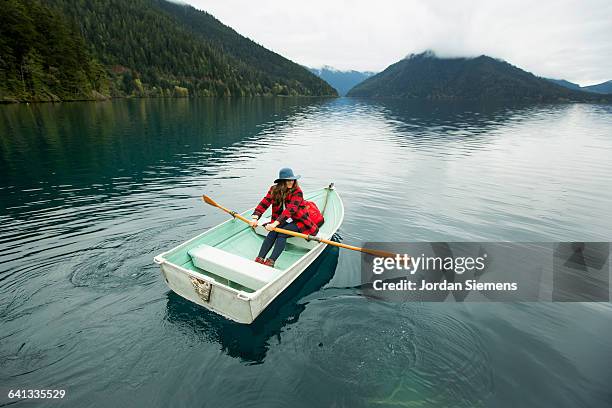 a woman in a row boat. - rowboat bildbanksfoton och bilder