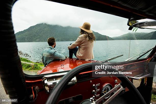 a couple in a convertible. - sitting on top of car stock pictures, royalty-free photos & images