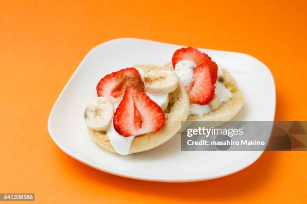 strawberry and banana slicing on english muffins - english muffin stock pictures, royalty-free photos & images