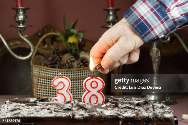 man burning candles with a lighter - dark chocolate man stock pictures, royalty-free photos & images