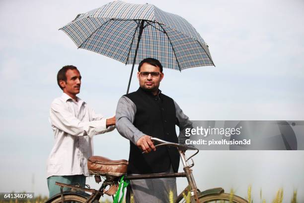 landlord with his assistant - holding umbrella stock pictures, royalty-free photos & images