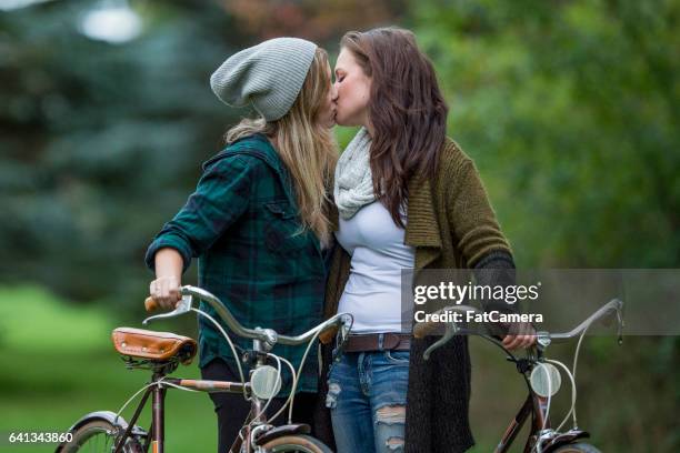 couple kissing at the park - fat lesbian stock pictures, royalty-free photos & images