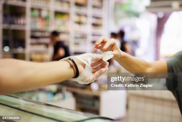 salesman handing cheese sample to client - cheese shop stock-fotos und bilder