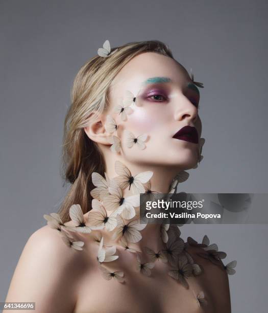 young beautiful woman with butterflies on her neck and face - animal representation stock pictures, royalty-free photos & images