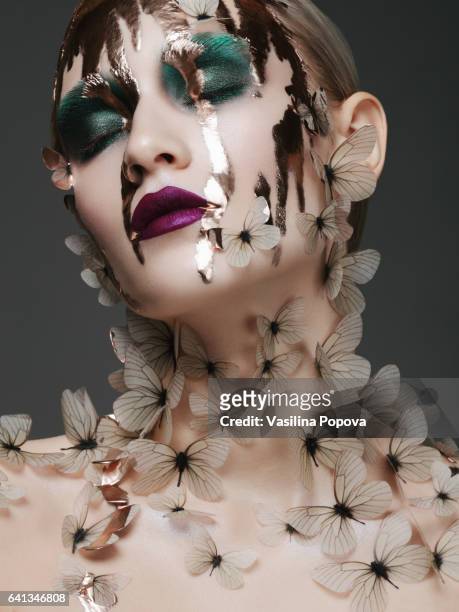 beautiful woman with butterflies and liquid gold on her face - green eyeshadow stock pictures, royalty-free photos & images