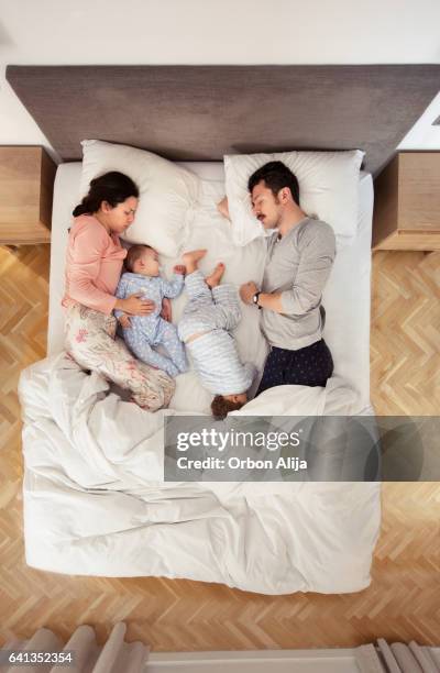 familie im bett  - above view of man sleeping on bed stock-fotos und bilder