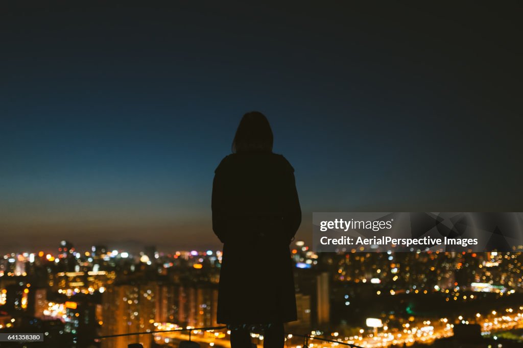 Young female overlooking the stunning view of city