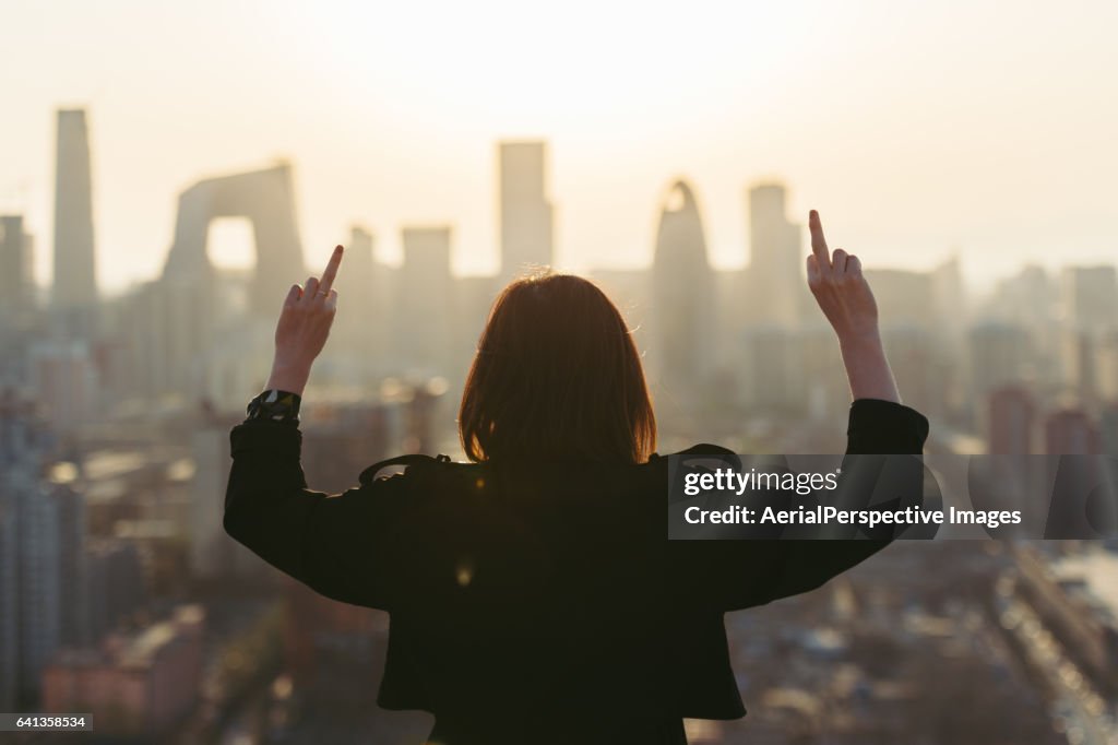 Rear View of Woman Giving Middle Finger in City