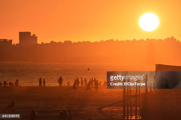 people enjoying the beach at sunset, malvin beach, montevideo, uruguay - uruguay stock pictures, royalty-free photos & images