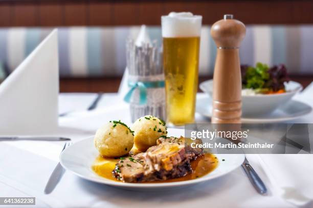 roasted pork with dumplings and sauce served with beer - traditionally austrian stock pictures, royalty-free photos & images