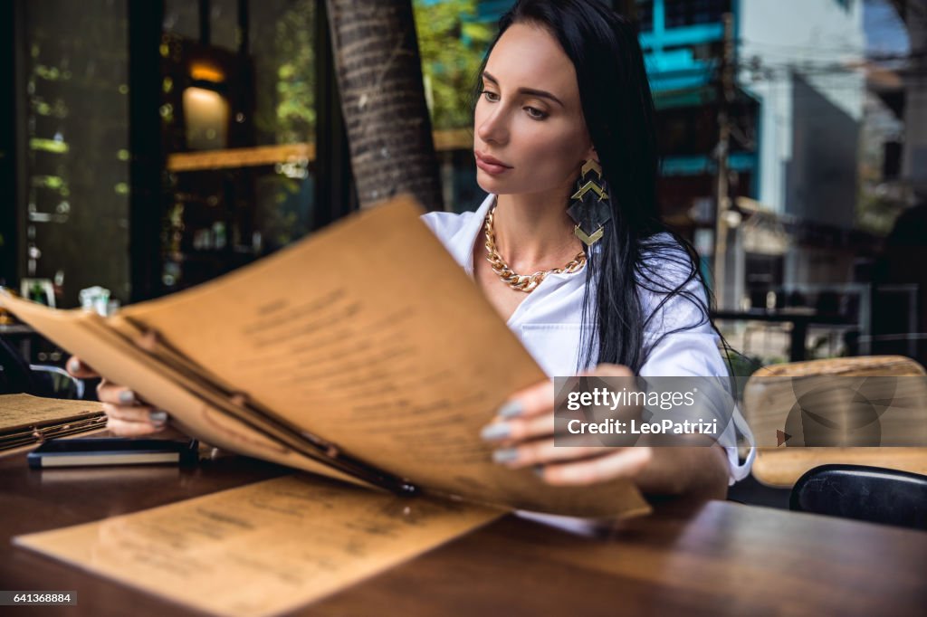 Woman at lunch break sitting in outdoor restaurant bar